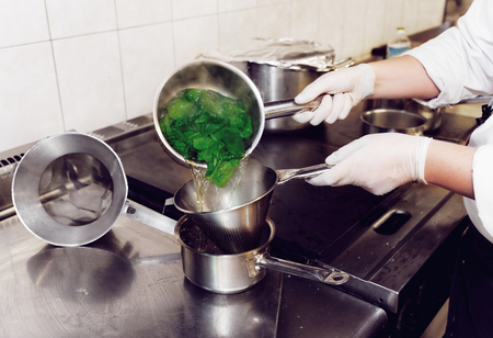Chef draining spinach after blanching